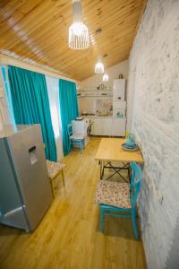 Zimmer mit einem Tisch und Stühlen sowie einer Küche in der Unterkunft Nino's House in Tsinandali