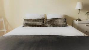 a bed with a black and white pillow on it at cosy2bedroomapartment in Loulé +23 photos
