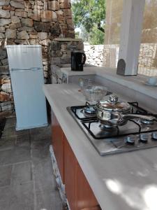 a kitchen with a stove and a white refrigerator at Piccolo Trullo Salentino in Marina di Pescoluse