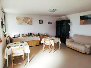 Lo Spicchio b&b في ألغيرو: غرفة معيشة مع طاولتين وأريكة