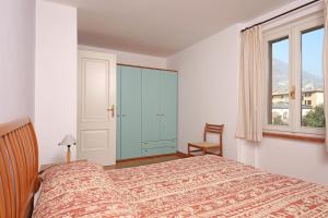 a bedroom with a bed and a cabinet and a window at Apartment Casa Caterina in Gargnano +10 photos