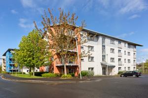 a large white building with a tree in front of it at Clarion Village in Sligo