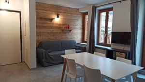 een woonkamer met een witte tafel en een bank bij Il Fouia Apartments in Pragelato