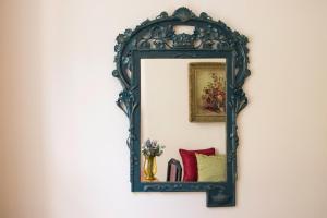 a mirror with a blue frame hanging on a wall at Prague Castle apartment Vintage in Prague