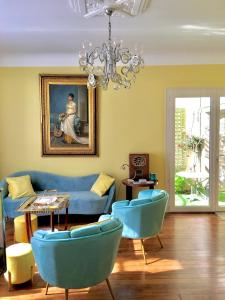 un salon avec des chaises bleues et un lustre dans l'établissement Le 1930, chambres d’hôtes de charme, à Cosne Cours sur Loire