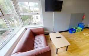 ein Wohnzimmer mit einem Sofa und einem Tisch in der Unterkunft Phoenix Halls in Brighton & Hove