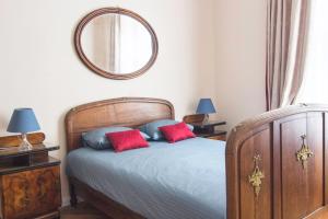 a bedroom with a bed with two red pillows and a mirror at Prague Castle apartment Vintage in Prague