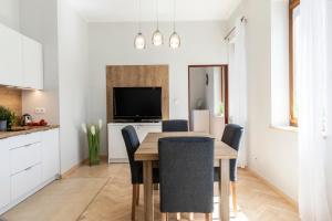 a kitchen and dining room with a table and chairs at udanypobyt Apartament z Basenem in Zakopane