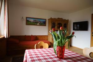 uma sala de estar com uma mesa com um vaso de flores em Ferienwohnung Frech em Thaur