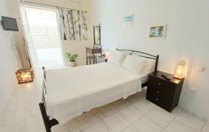 une chambre avec un grand lit blanc et une fenêtre dans l'établissement Koukounari 2 Rooms, à Skala 13 autres photos