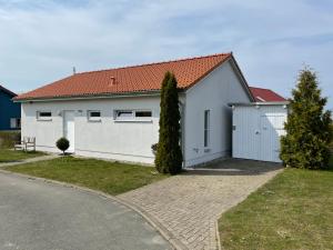 Casa blanca con techo rojo y entrada en Ein Haus am Meer, en Boiensdorf