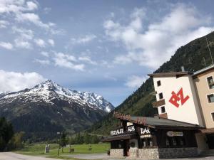 um alojamento de esqui com uma montanha ao fundo em Piz-Hotel em Sankt Leonhard im Pitztal