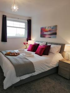 a bedroom with a large white bed with red pillows at Seaforth House Apartment in Elgin