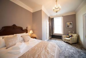 a bedroom with a large bed and a chandelier at East Walls Hotel in Chichester