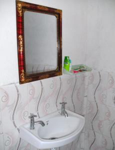 a bathroom with a sink and a mirror at Vamoose Bablu in Khajurāho