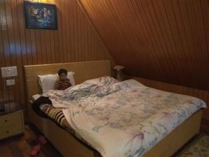 カジュラーホーにあるVamoose Babluの小さな子供が部屋のベッドで寝ている