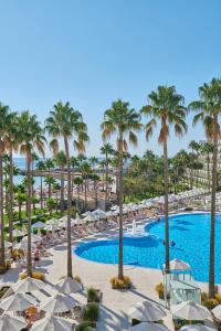 
a beach filled with palm trees and palm trees at Hipotels Mediterraneo Hotel - Adults Only in Sa Coma
