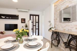 a dining room with a table and chairs and a brick wall at Ela in Rijeka