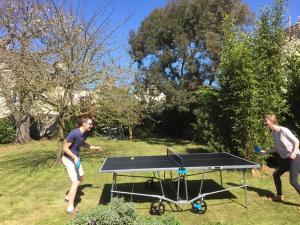 two men playing ping pong on a ping pong table at Maison Matignon Bretagne in Matignon