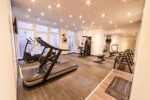 a gym with treadmills and exercise equipment in a room at PLAZA Residence Stuttgart-Ditzingen in Ditzingen