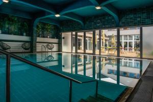 ノスヴァイにあるTündérkert Hotel Noszvajの青い水の屋内スイミングプール