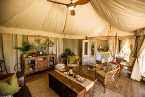 ein Wohnzimmer mit einem Zelt mit einem Tisch und Stühlen in der Unterkunft Orchard Valley Glamping in Otorohanga