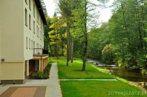 una pasarela junto a un edificio junto a un río en Hotel Mir-Jan SPA, en Lądek-Zdrój