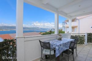 einen Tisch auf einem Balkon mit Blick auf das Wasser in der Unterkunft Apartments Bagaric in Trogir