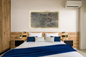 1 dormitorio con 1 cama grande con almohadas azules y blancas en Just Creta Sea View apartment, en La Canea