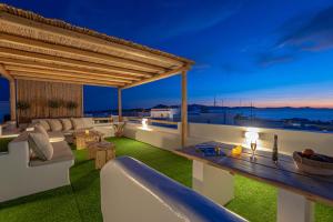 a rooftop patio with a view of the ocean at night at Naxian Horizon in Naxos Chora