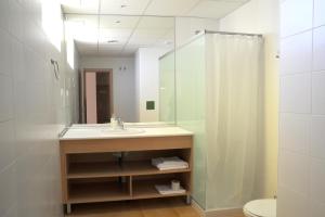 un baño con lavabo y espejo en Apartamentos Turisticos Mediterraneo, en Cartagena
