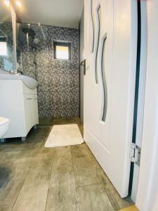 ein Badezimmer mit einer weißen Tür und einem Waschbecken in der Unterkunft Casa Maria in Alba Iulia
