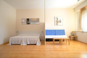 Una habitación con dos camas y un banco en ella. en Apartamentos Turisticos Mediterraneo, en Cartagena