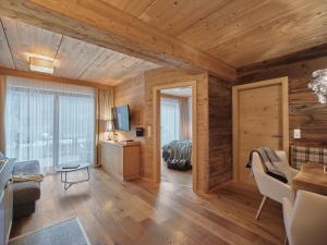 uma sala de estar com paredes de madeira e uma grande janela em Boutique Apartment Sonnenhang - incl Infinity Pool em Fliess