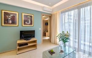 a living room with a television and a large window at Leonidas Hotel & Apartments in Rethymno Town