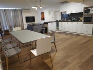 cocina y sala de estar con mesa blanca y sillas en Dekel-City center and Sea view -new listing, en Eilat