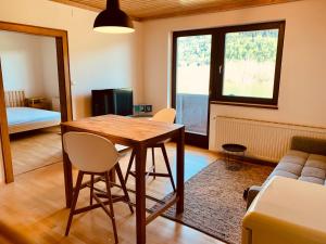 a living room with a wooden table and chairs at Appartements Skruba in Steindorf am Ossiacher See