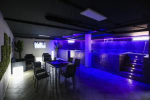 una stanza con tavolo e sedie e una parete con luci viola di Barlovento Planet Costa Dorada a Vilafortuny