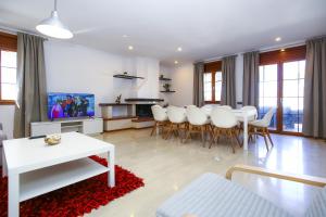 un soggiorno con tavolo e sedie bianchi di Barlovento Planet Costa Dorada a Vilafortuny