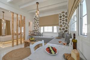 a living room with a table with a bowl of fruit and wine glasses at Naxian Horizon in Naxos Chora