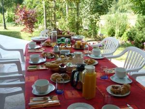 una mesa roja con comida y bebidas. en Chambres d'Hôtes de l'Auraine, en Limoges