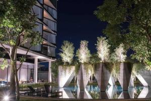 a row of trees in front of a building at night at Livist Resort phetchabun in Phetchabun