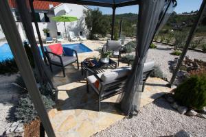 een patio met een tafel en stoelen en een zwembad bij Holiday Home Ela in Dračevica