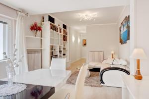 a white living room with white chairs and a table at Luni Mare Bright Terrace Flat with Parking in Marinella di Sarzana