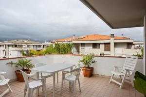 patio con mesa y sillas en el balcón en Luni Mare Bright Terrace Flat with Parking, en Marinella di Sarzana