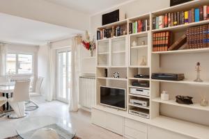 a living room with a large white book shelf at Luni Mare Bright Terrace Flat with Parking in Marinella di Sarzana