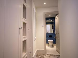a bathroom with a toilet and a hallway with a door at East Walls Hotel in Chichester