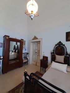 a bedroom with a bed and a mirror and a chandelier at Villa Longo de Bellis in Bari