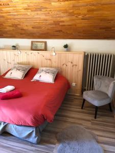 1 dormitorio con 1 cama roja y 1 silla en Hôtel, Le Refuge Napoléon, en Vars