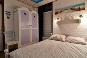a bedroom with a white bed with a shelf and a sink at Bungalowpark De Toekomst in Ouddorp